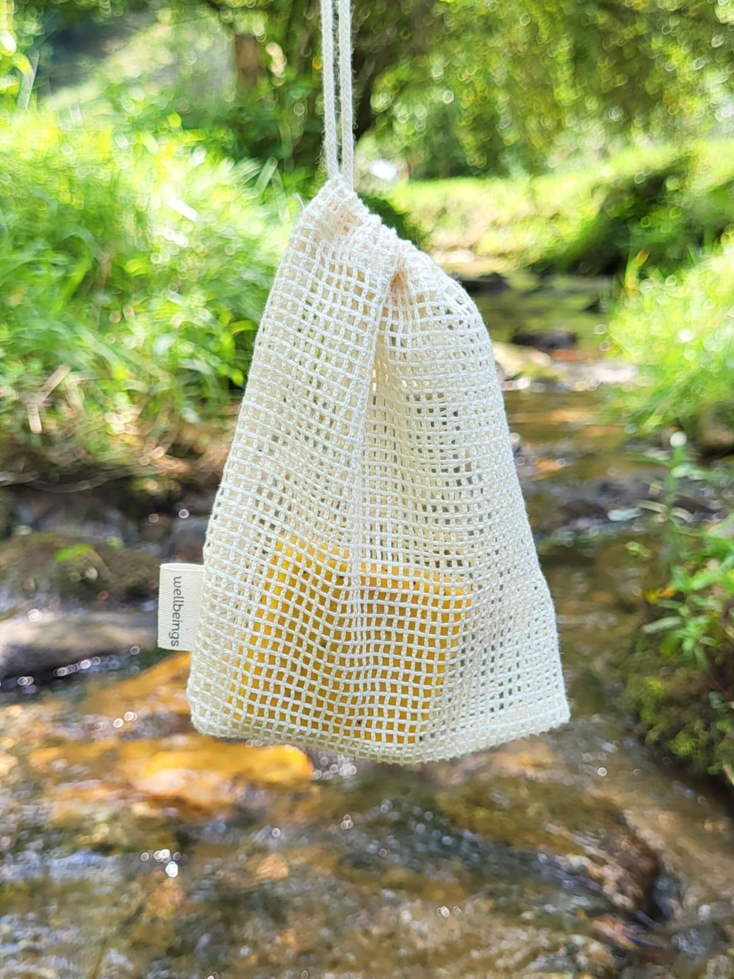 Organic cotton shower pouch in front of a creek