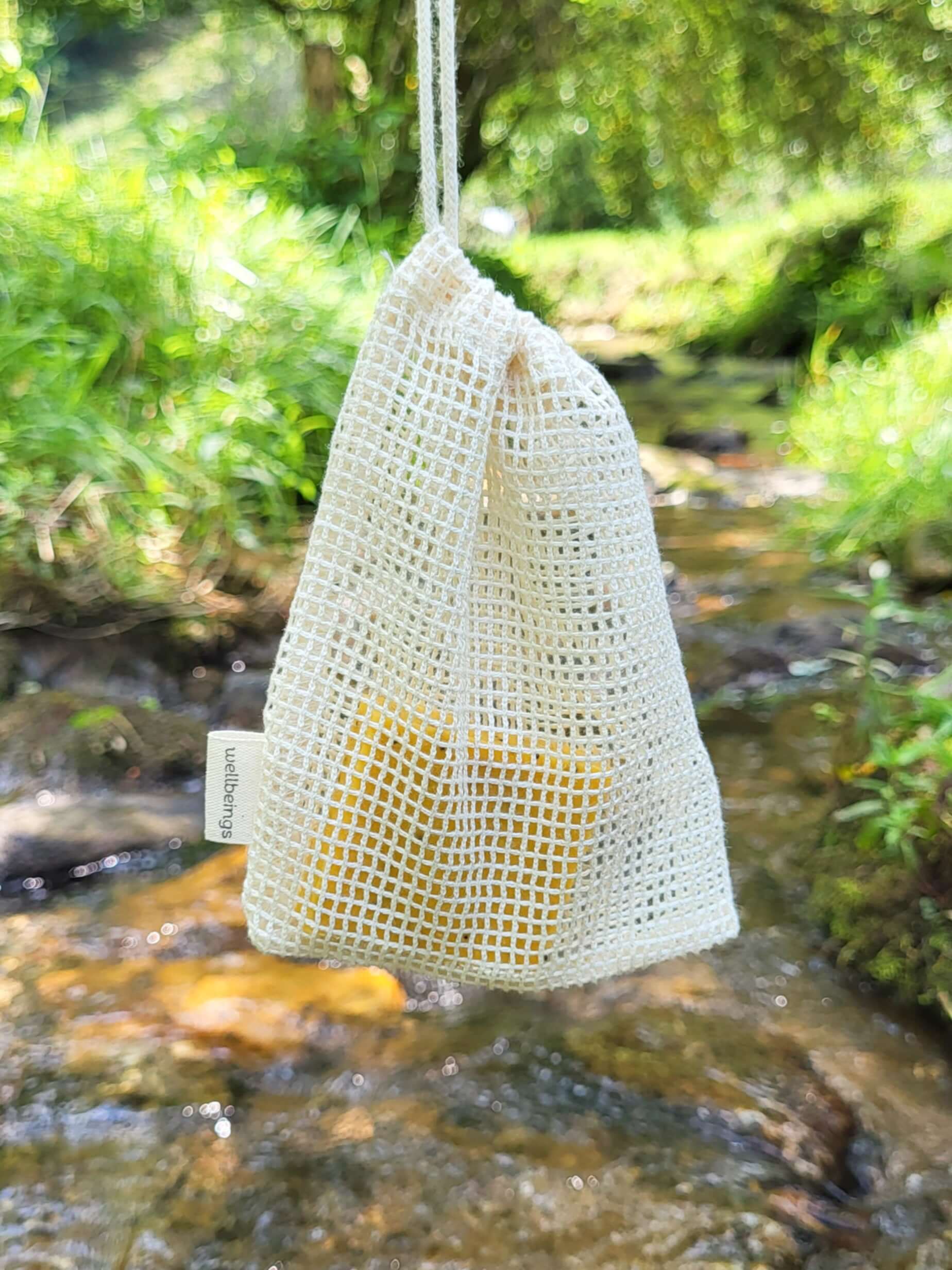 Organic cotton shower pouch in front of a creek