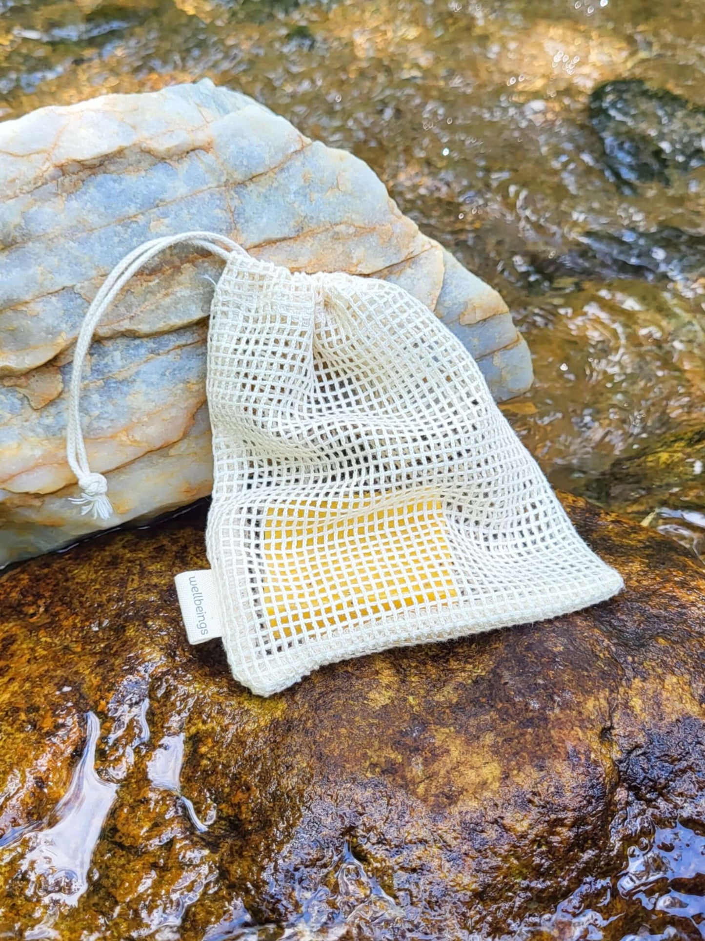 Organic cotton shower pouch in front of a creek