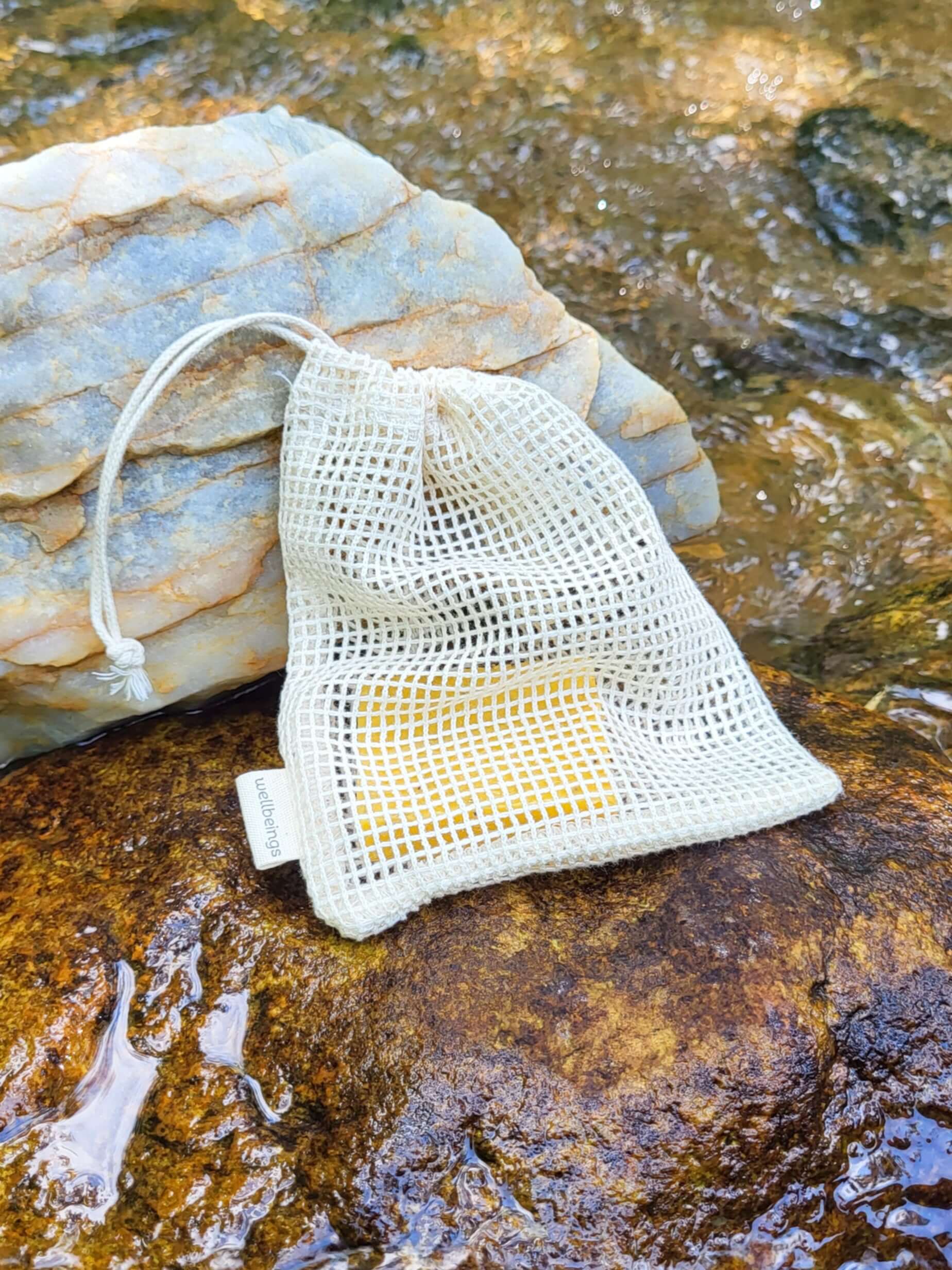 Organic cotton shower pouch in front of a creek