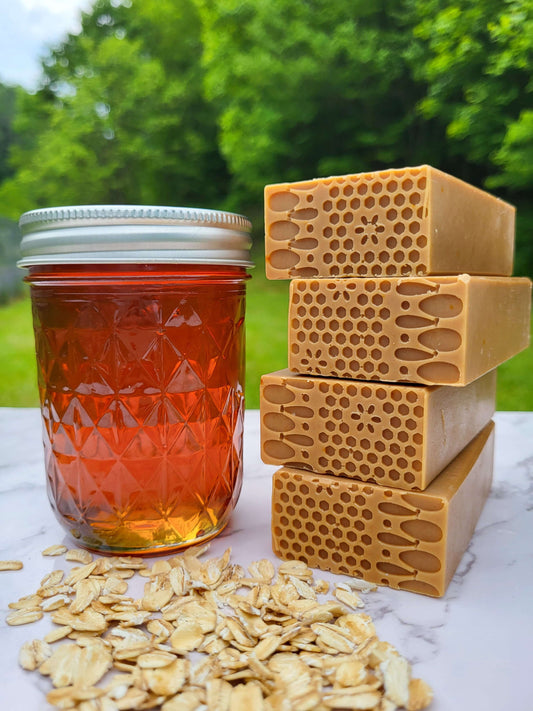 Old fashioned honey and oatmeal soap next to a jar of local raw honey and oats