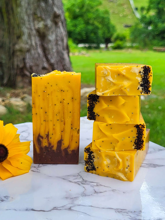 A stack of lard soaps that look like sunflowers in front of an old maple tree