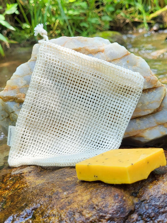 Organic cotton shower pouch in front of a creek